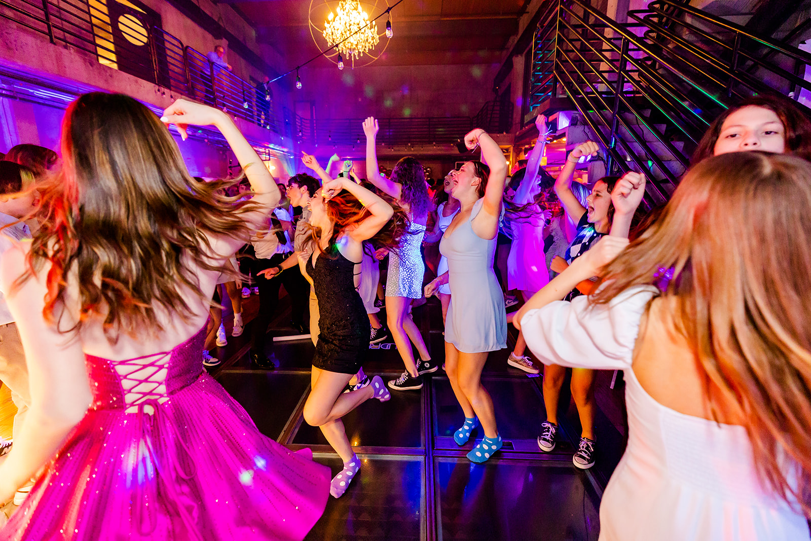 Teenage girls fist pump and dance on the dance floor during a Bat Mitzvah