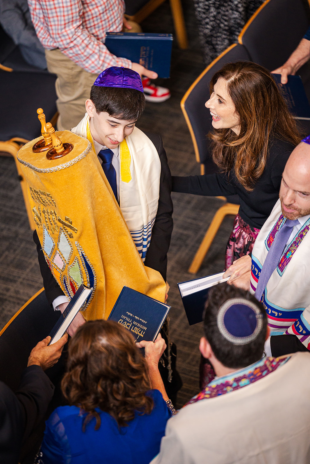 A boy carries the scroll while celebrating with family after his Bar Mitzvah service at a Chabad in Seattle