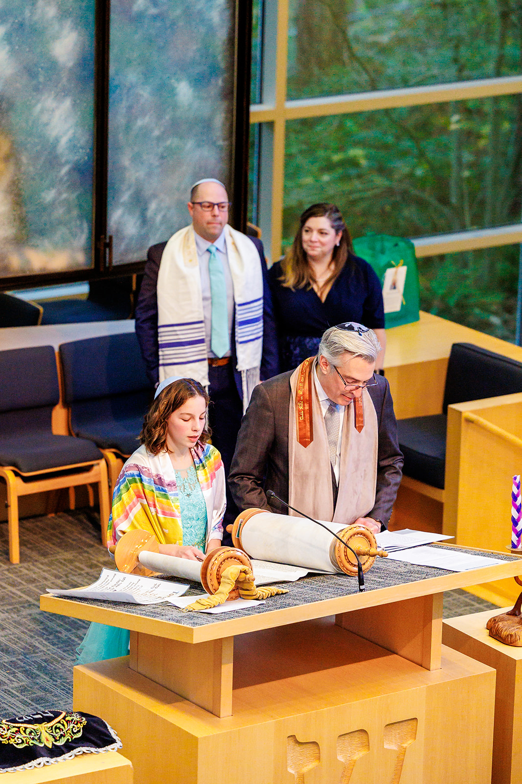 A teenage girl stands at the altar reading for her bat mitzvah with her rabbi at Eastside Torah Center