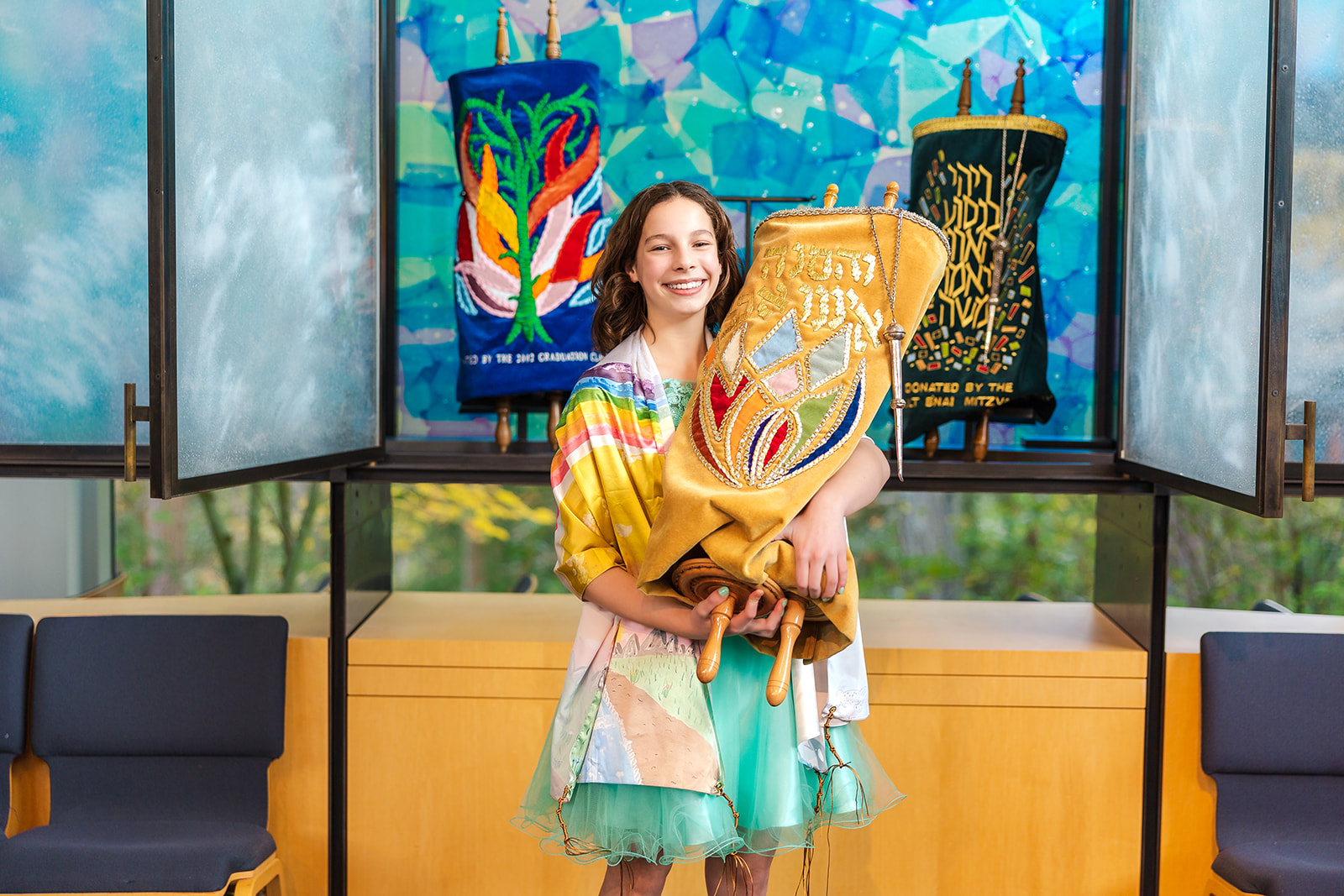 A teenage girl holds the scrolls after her bat mitzvah