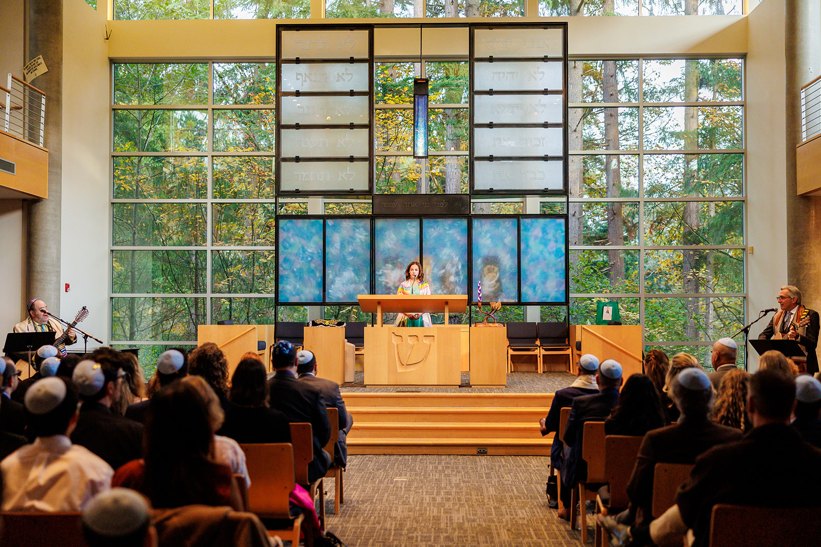 A teenage girl stands at the altar reading from the Torah during her Bat Mitzvah after attending Hebrew Schools In Seattle