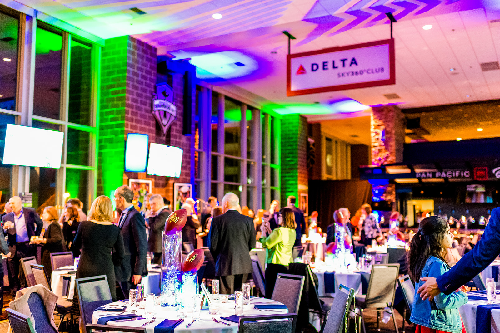 Details of a football themed Mitzvah with guests chatting in the Seattle Seahawks Stadium