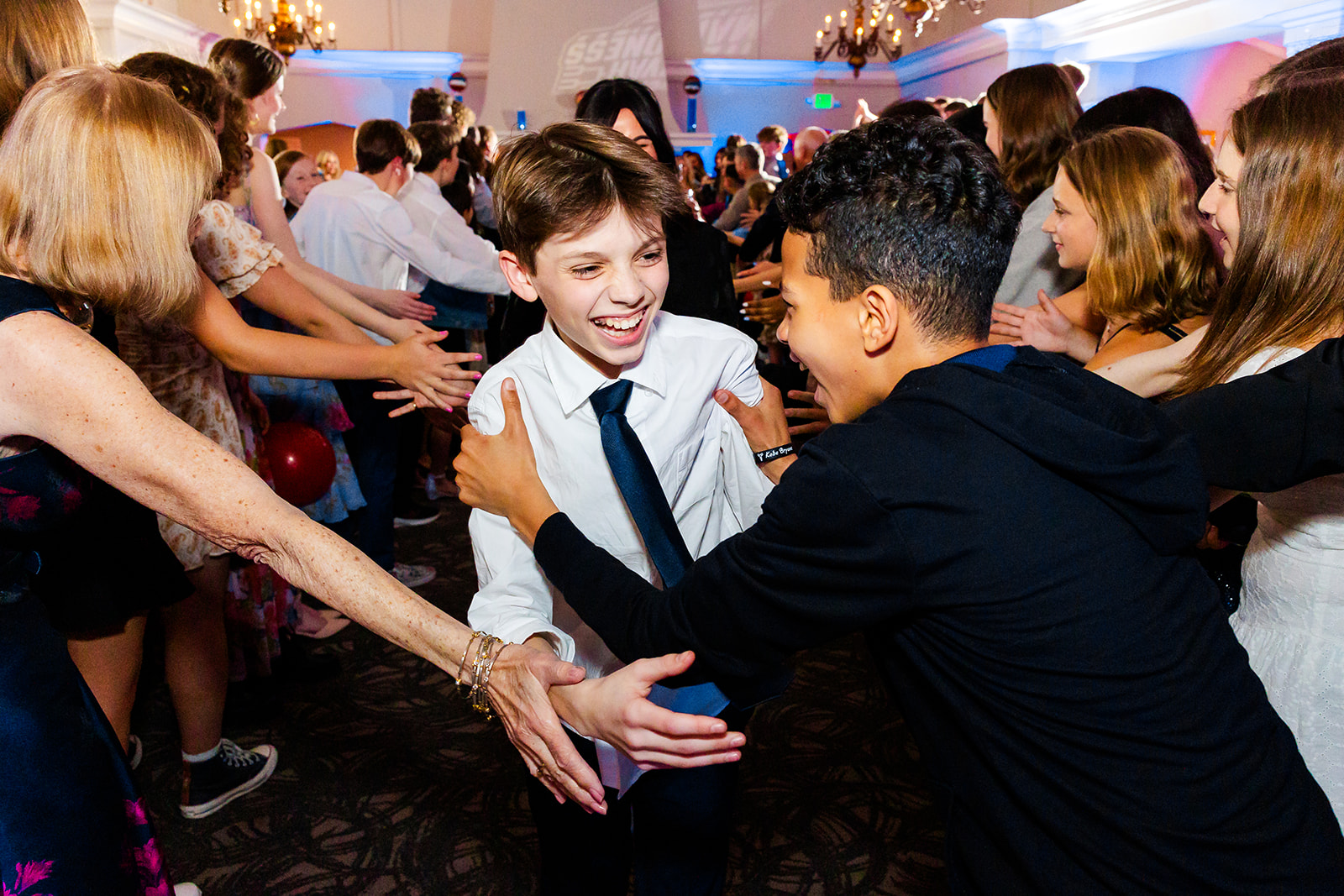 A boy celebrates and dances with his friends during a Mitzvah while attending Seattle Jewish Community School