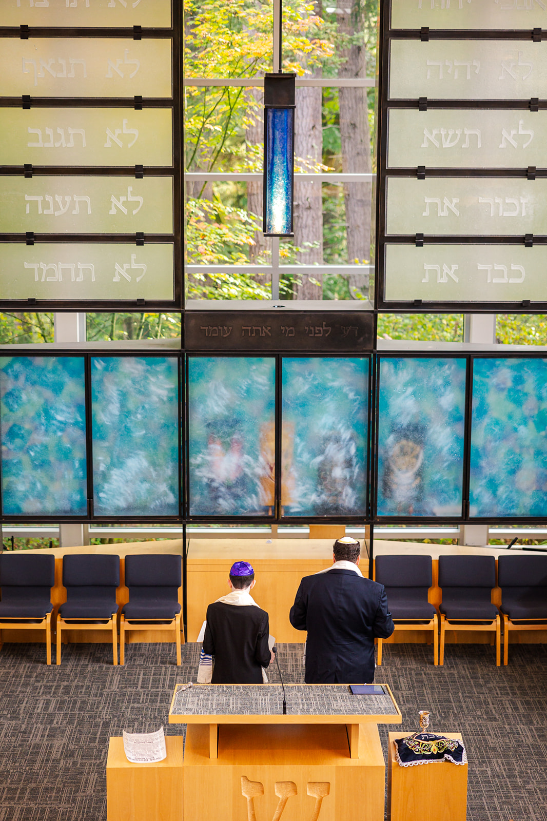 A boy stands with his Rabbi at the altar during his Bat Mitzvah at Temple de Hirsch Sinai