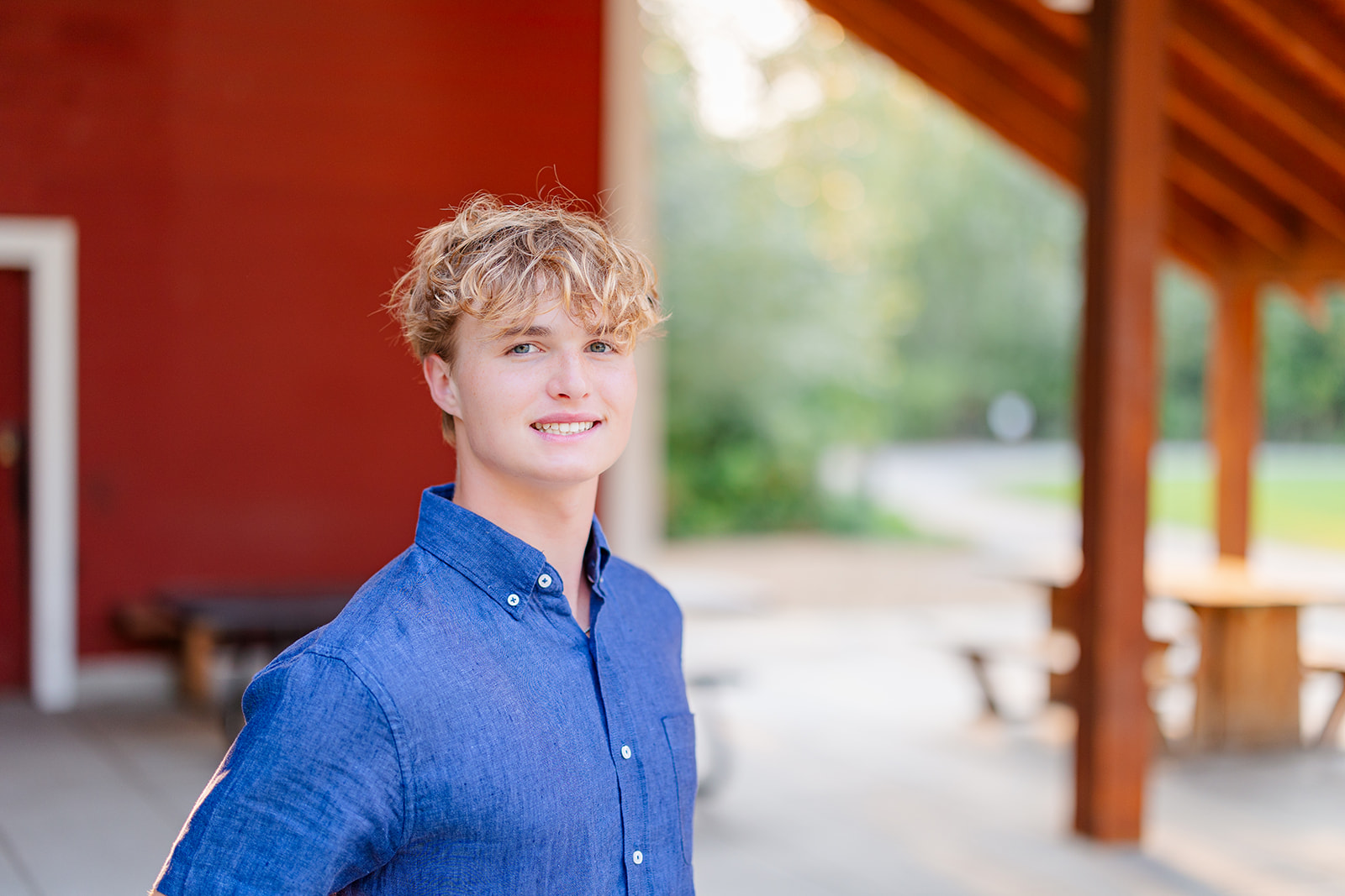 A high school senior stands on a patio at sunset in a denim shirt after finding high school senior volunteer opportunities seattle