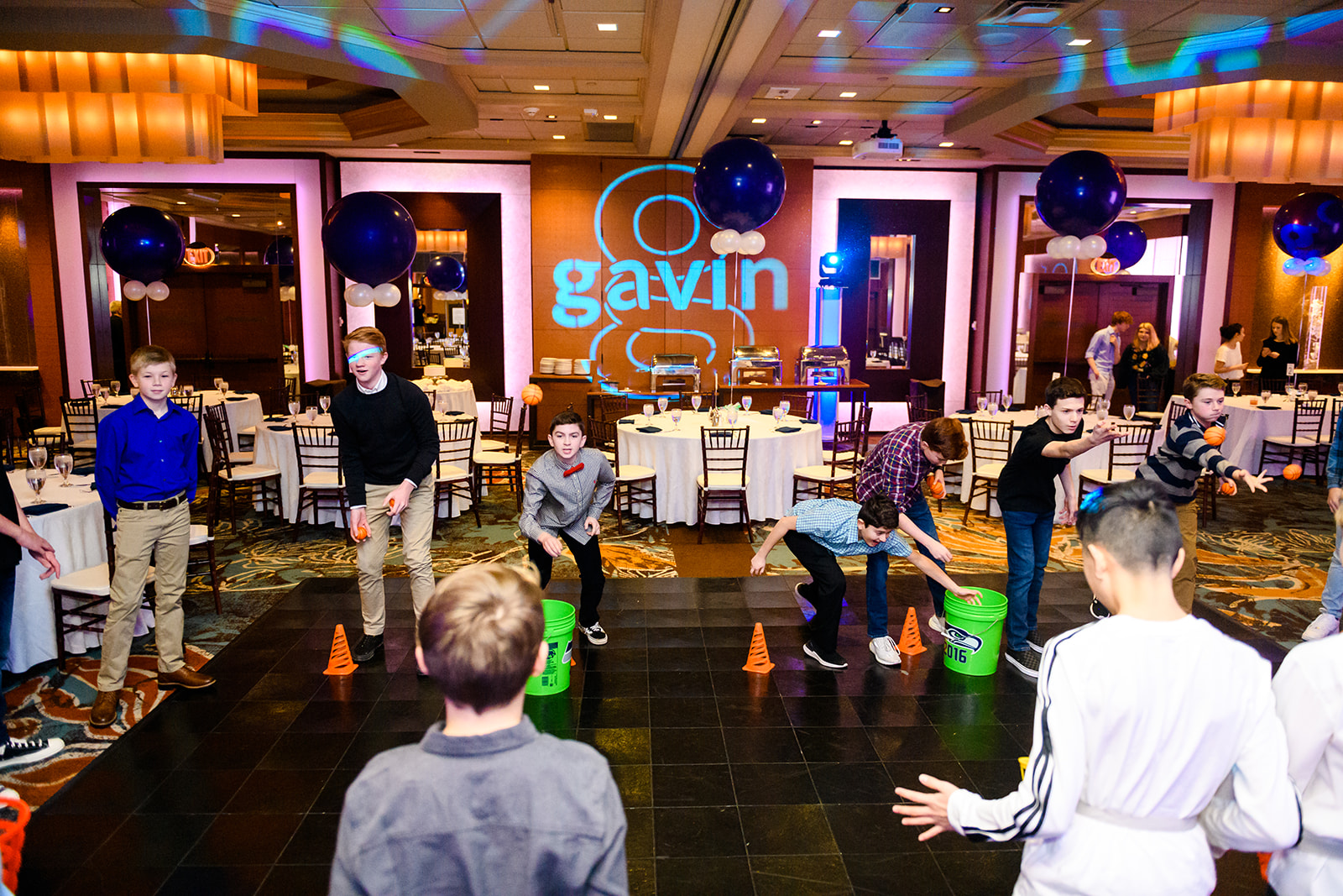 A group of boys play party games on a dance floor thanks to Party Supplies Seattle