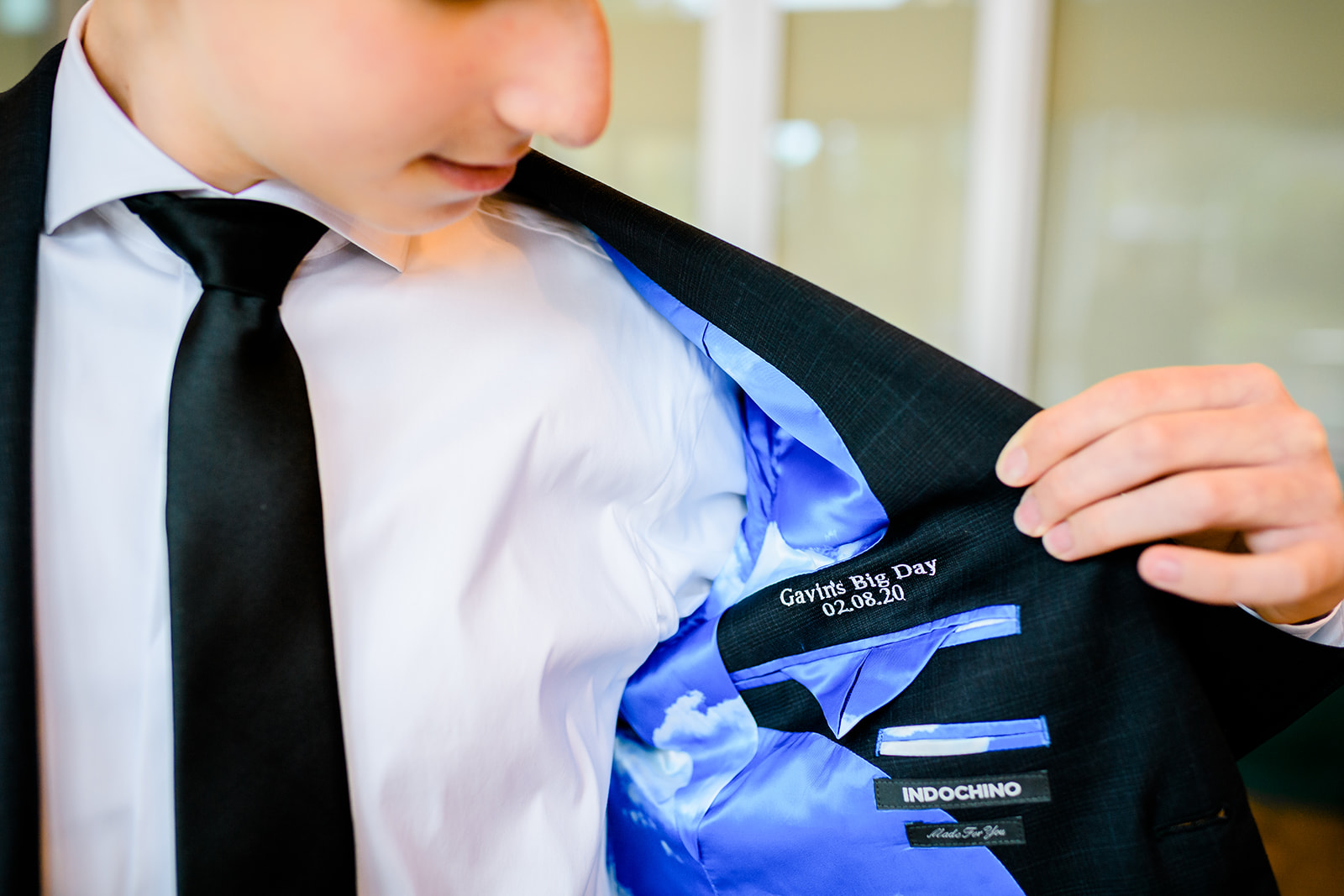 Details of a teen showing off his custom embroidered suit jacket