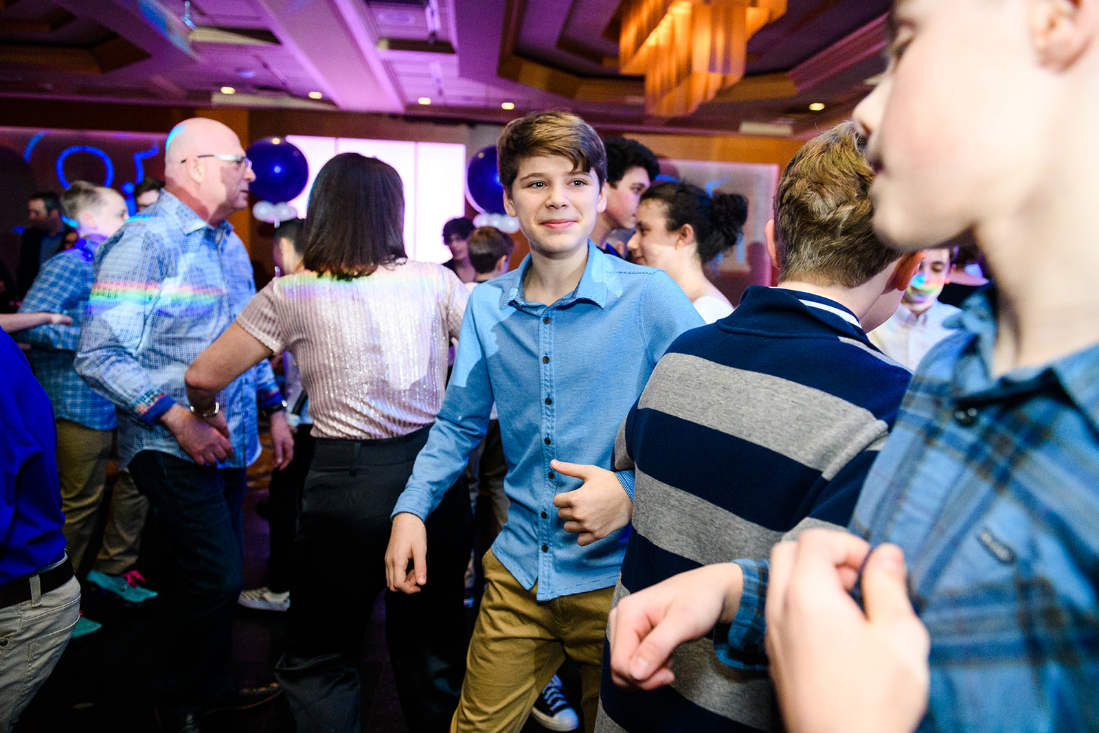 A teen boy dances with friends during his bar mitzvah with a Photobooth Rental Bellevue