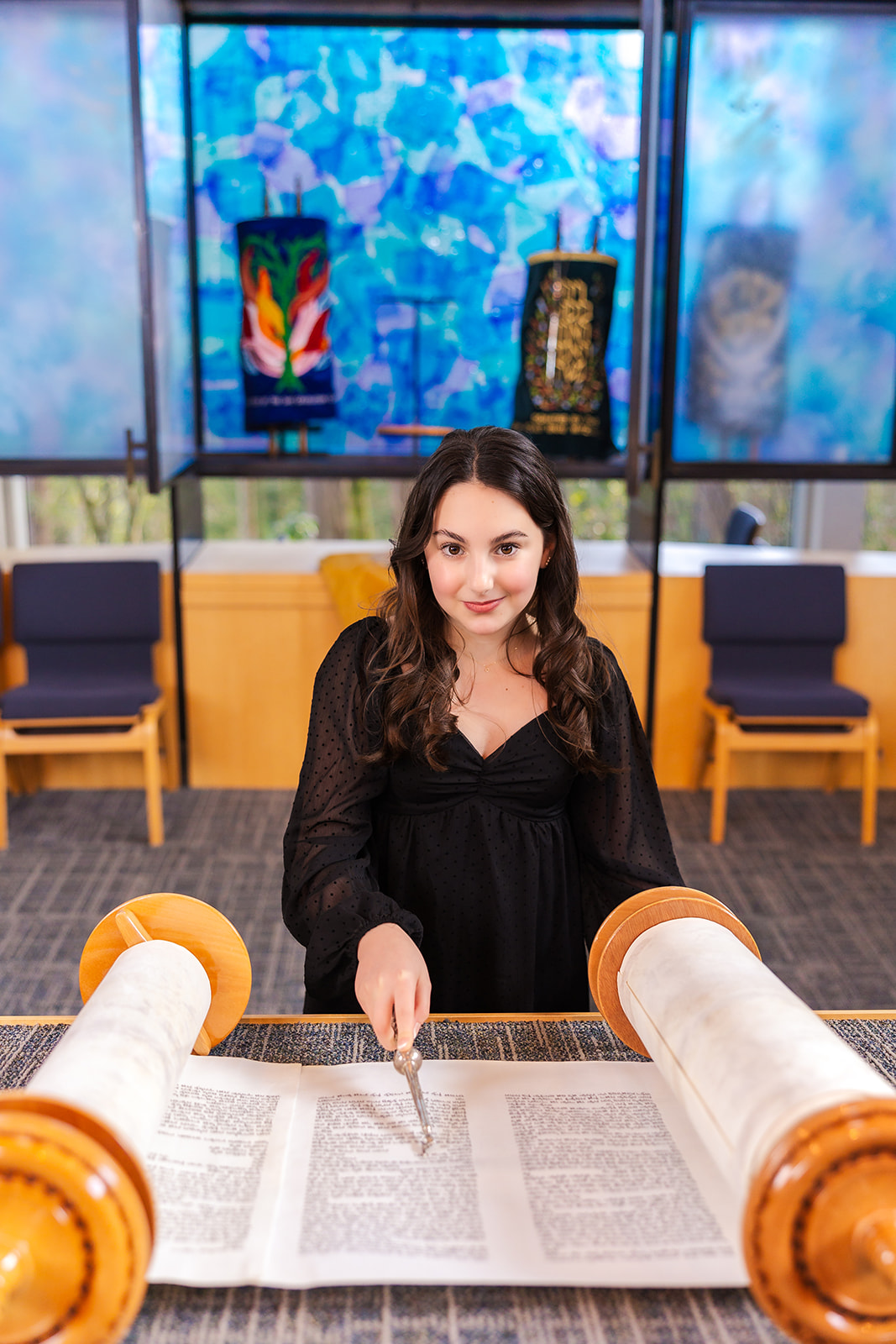 A teen girl stands at the altar reading from the torah in one of the Bellevue Synagogues