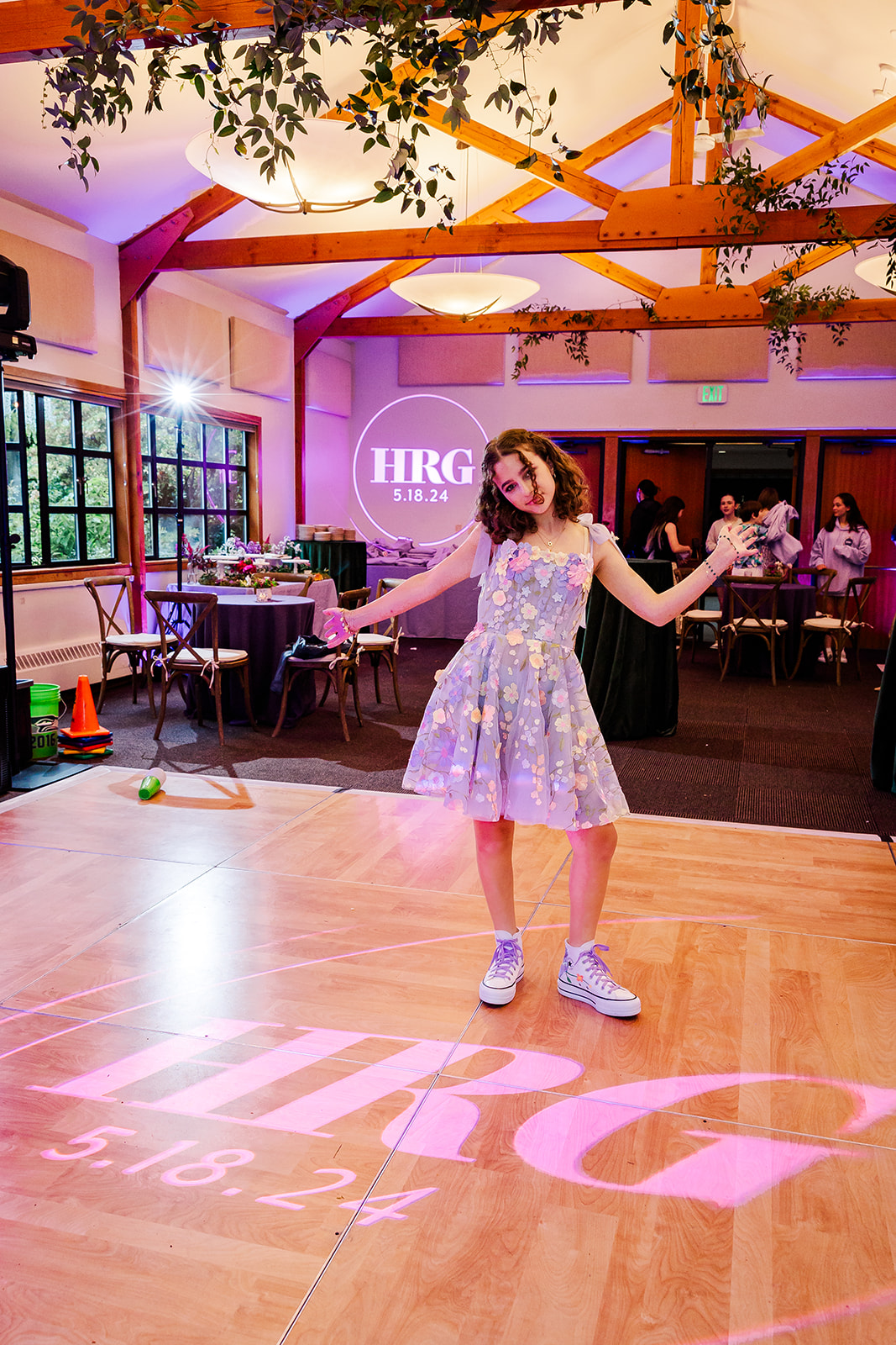 A young teen girl in a purple dress shows off her custom projection on the dance floor during her Mitzvah at one of the Issaquah Event Venues