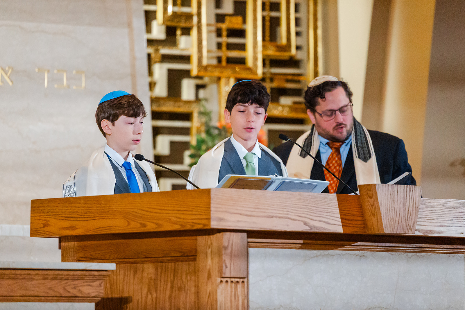 Two teen boys read from the Torah with their Rabbi at Chabad of Bellevue