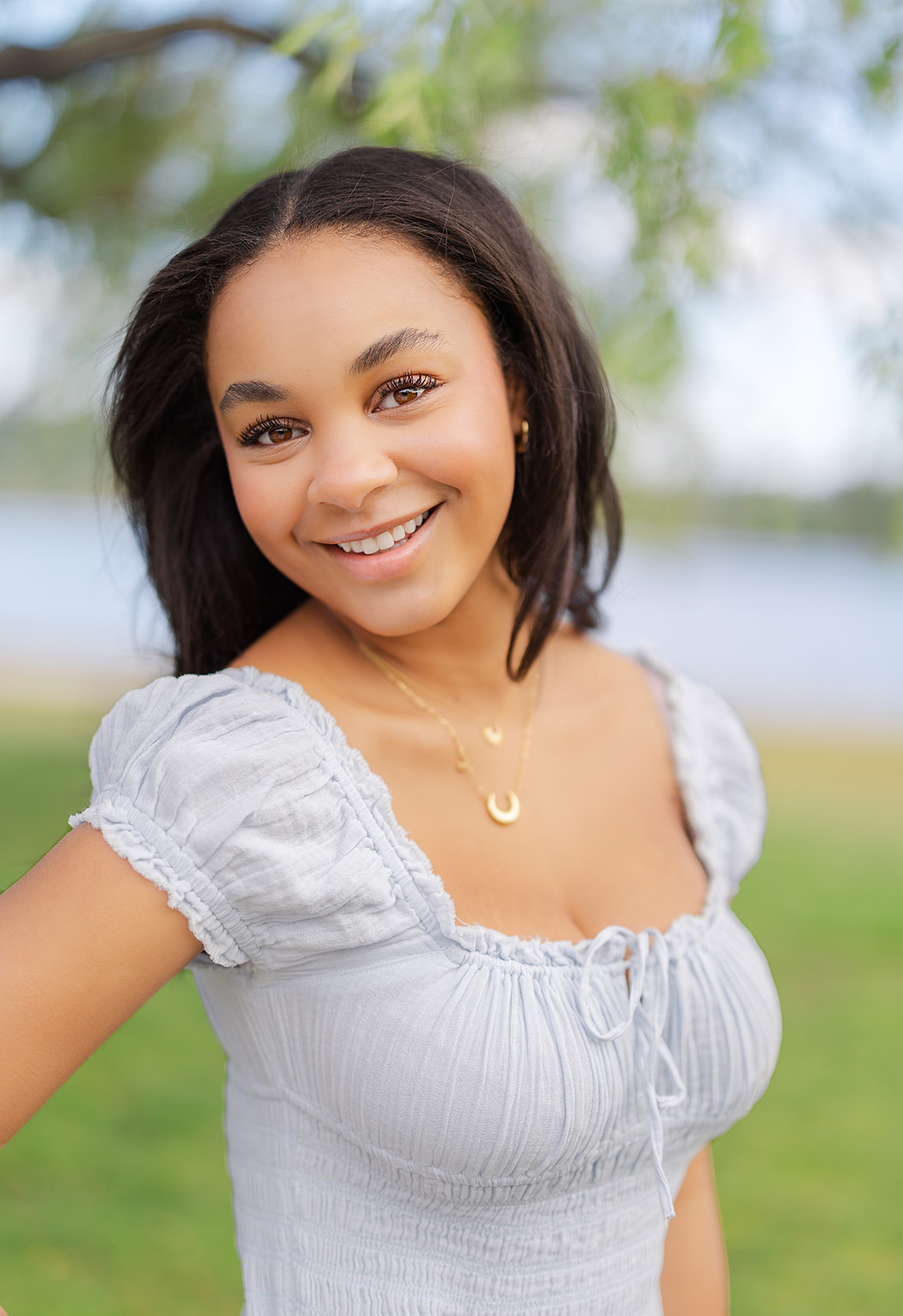 a high school senior smiles wile standing in a waterfront park after attending Issaquah Private Schools