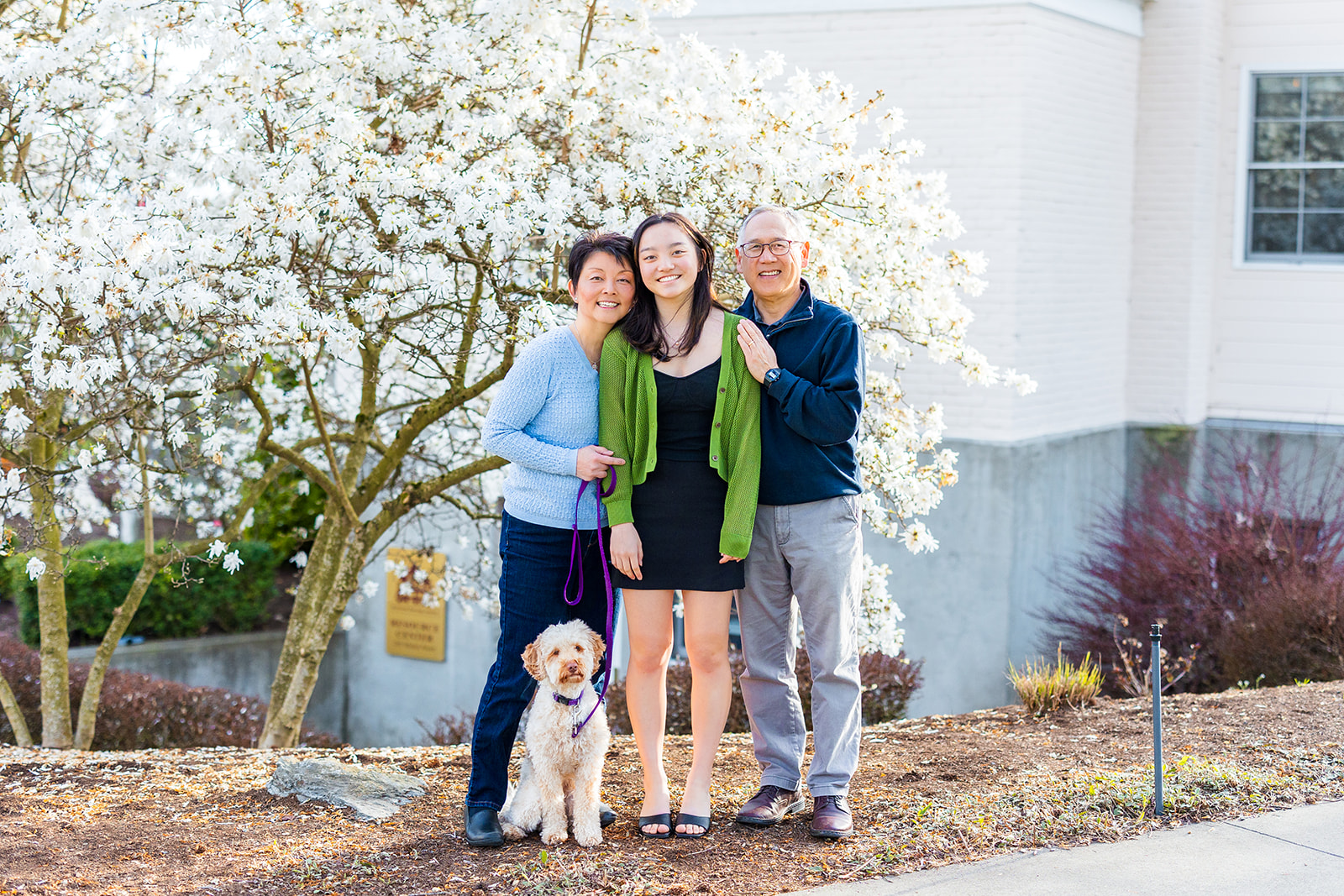 Proud parents stand with their dog hugging their high school senior daughter after some SAT Prep in Seattle