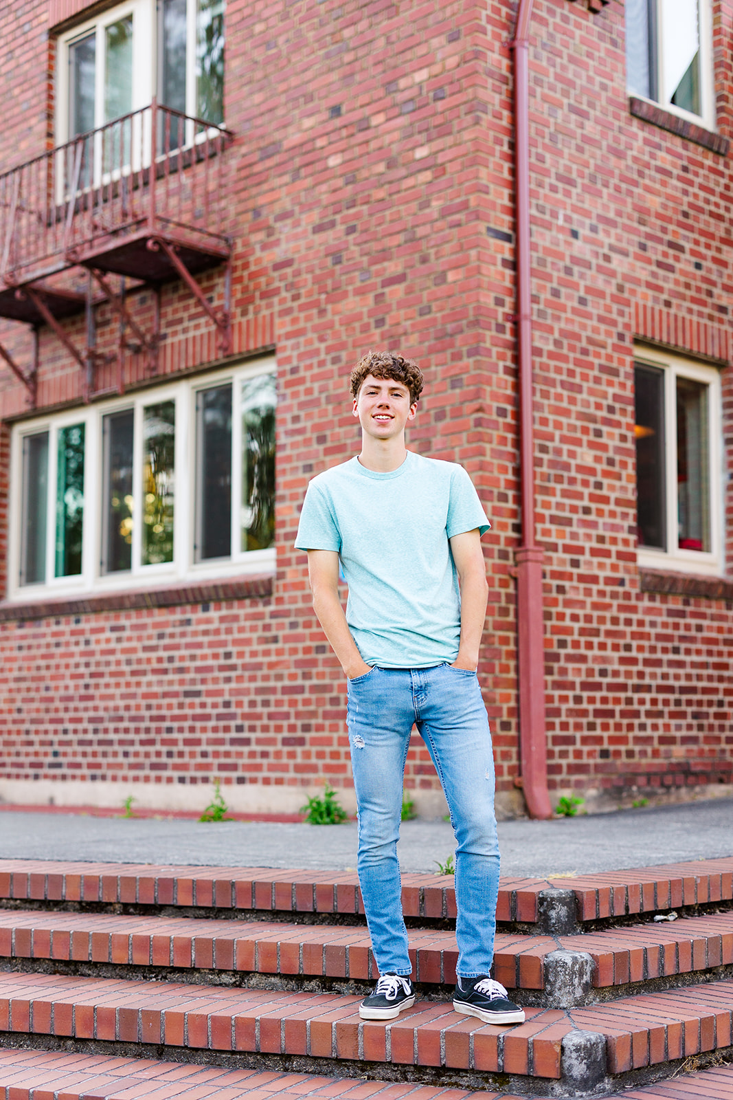 a high school senior stands on brick steps with hands in jean pockets after succeeding with Tutoring Renton, WA