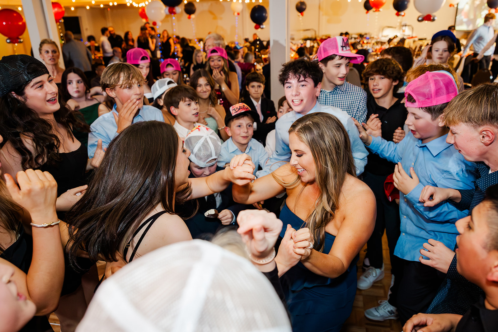 Two girls dance surrounded by friends at a Mitzvah catered by Down To Earth Cuisine