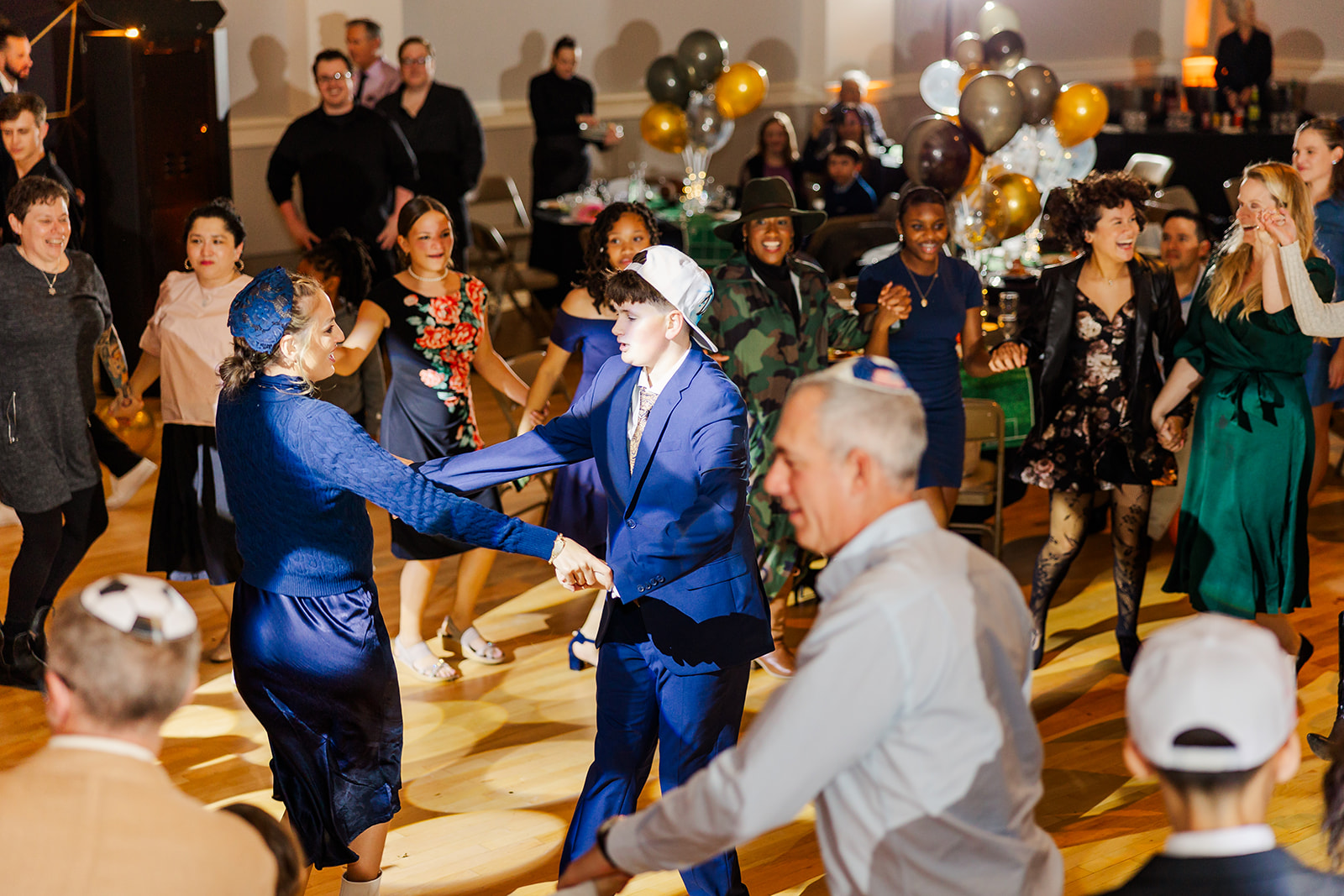 A boy in a blue suit dances with mom in a matching dress on the dance floor at one of the unique event venues in Seattle