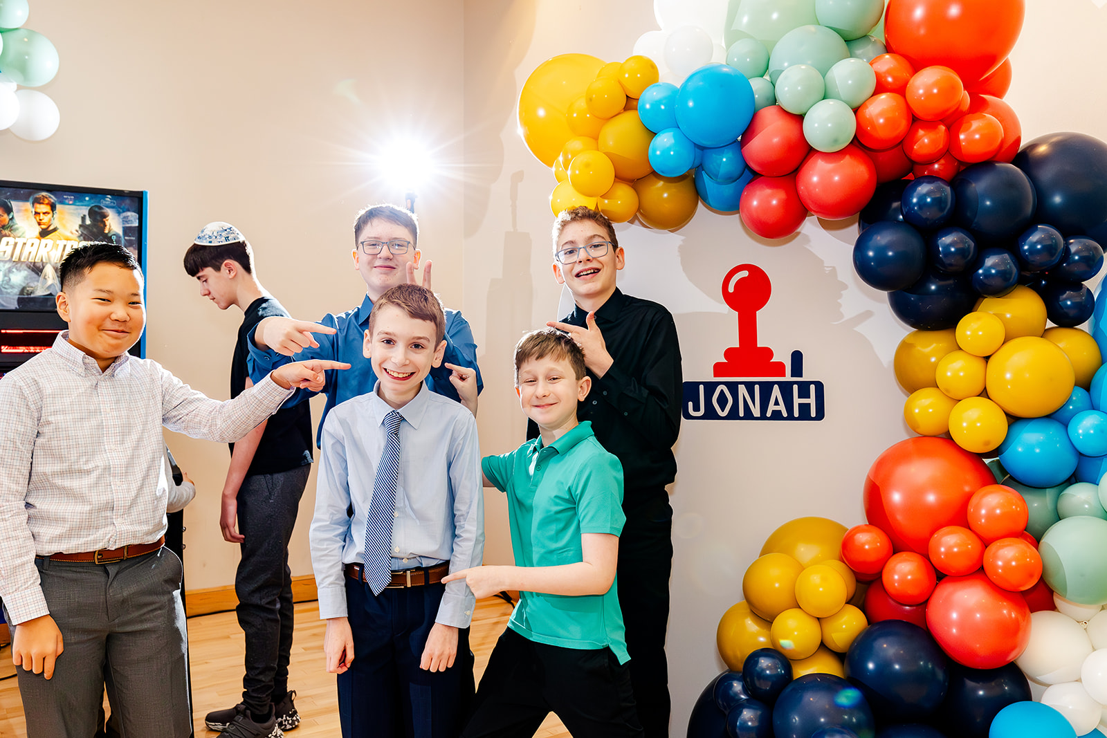 A group of boys point at the Bar Mitzvah boy in the center at one of the unique event venues in Seattle