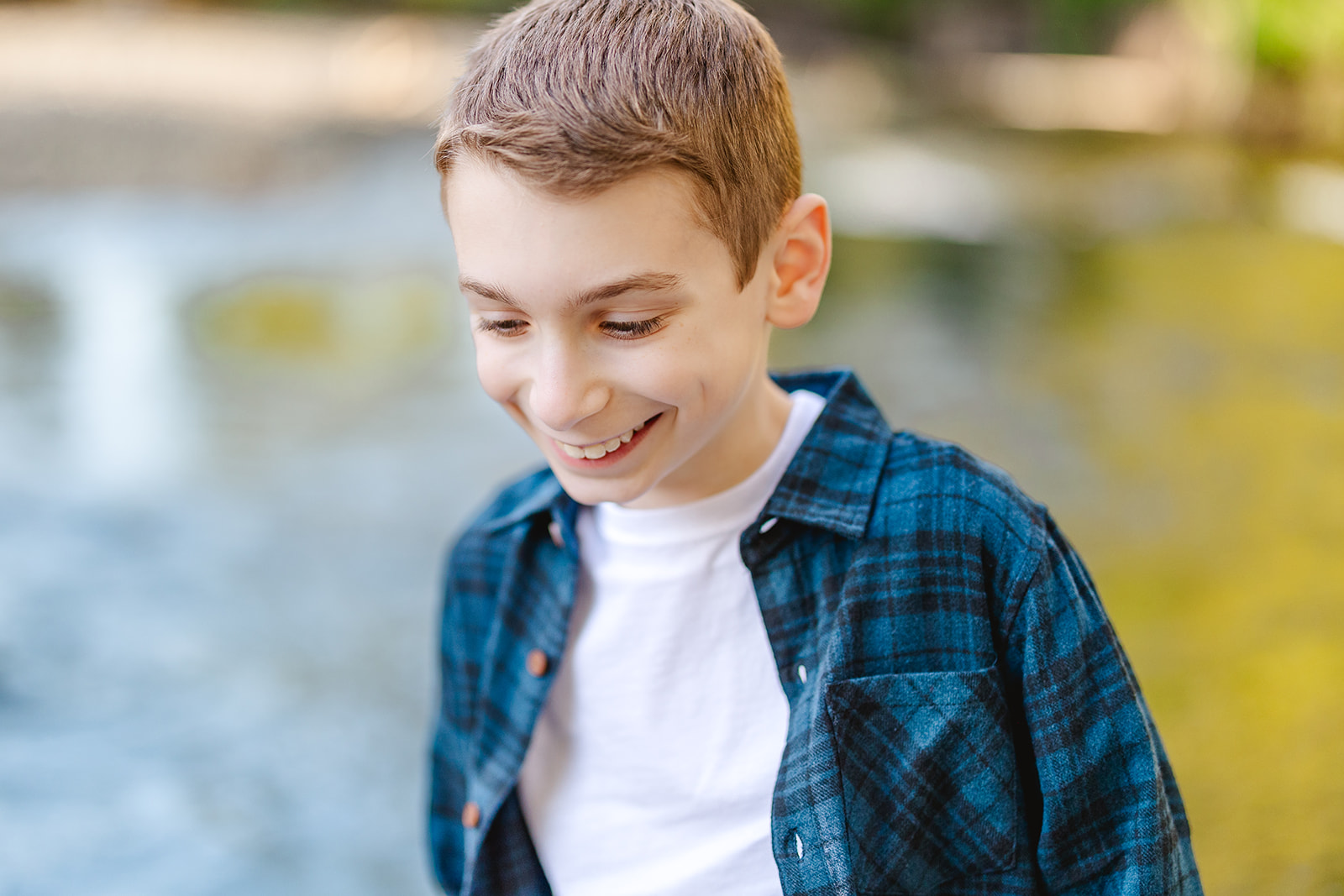 A smiling boy in a blue plaid shirt in a park while walking before tasting Catering in Issaquah