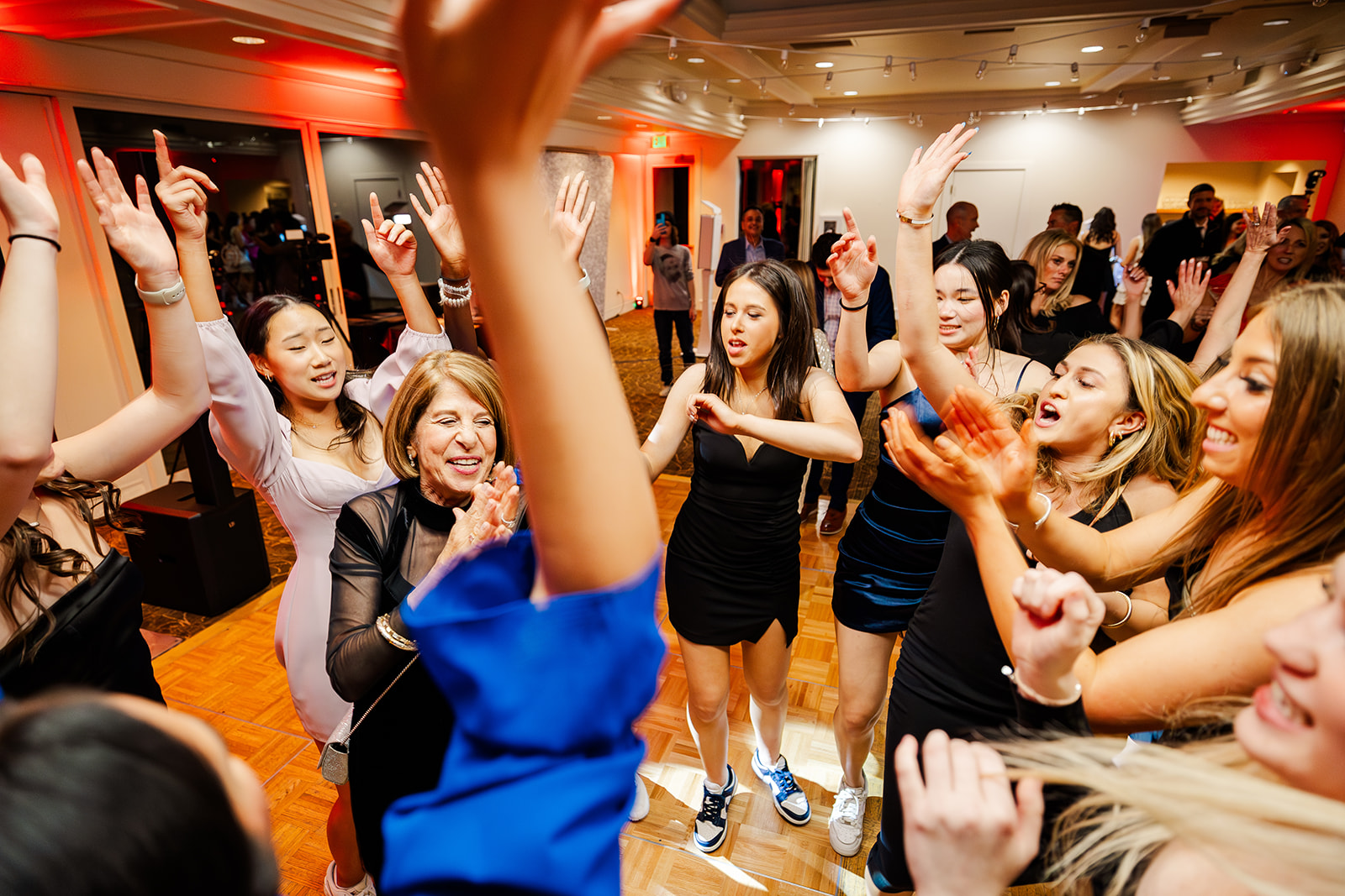 A group of teenage girls dance around a woman on the ance floor thanks to DJs in Bellevue