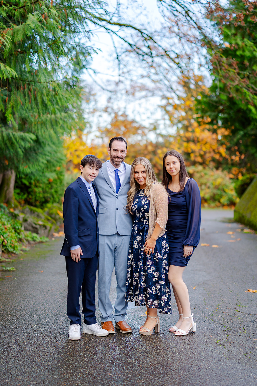 Proud parents stand in a driveway with their teen son and daughter before exploring large event venues in Seattle