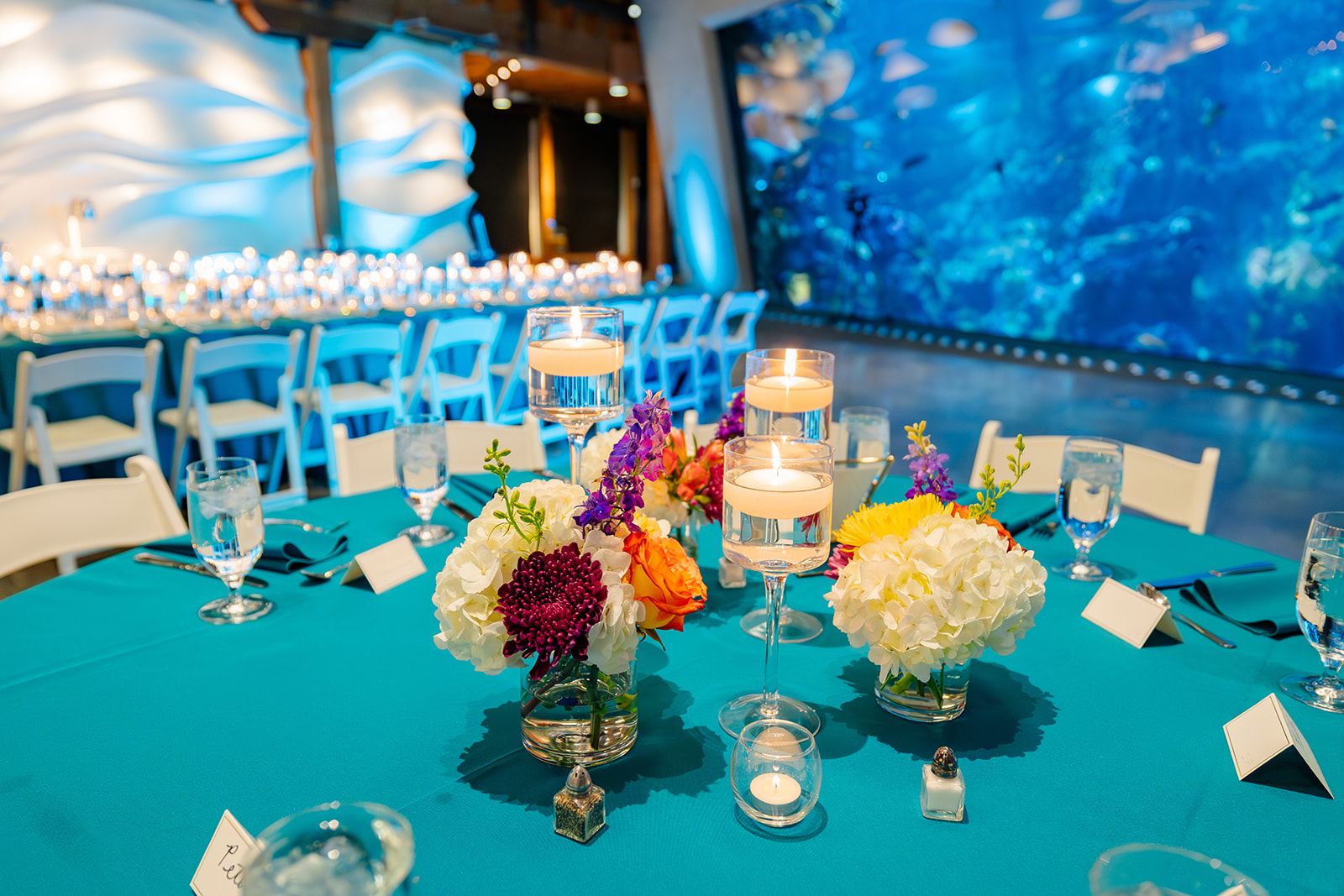 Details of a Bat Mitzvah table setting with blue linen and colorful florals