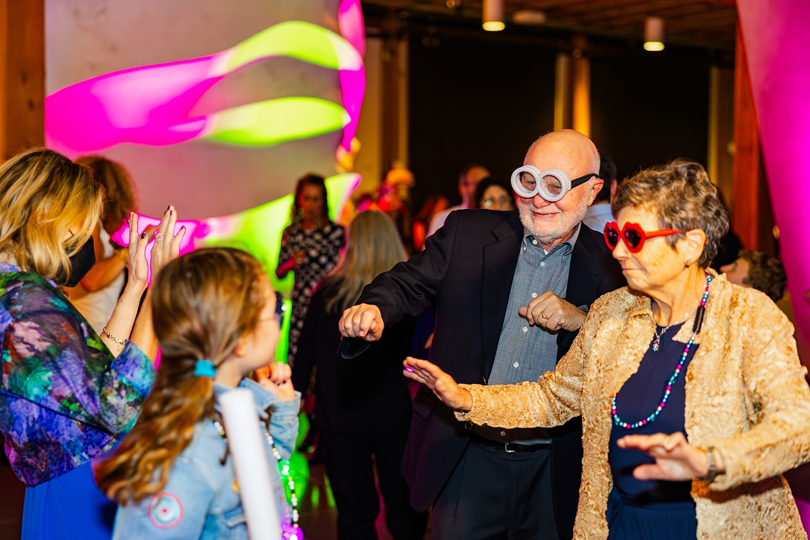 Happy grandparents dance in funny glasses with family after enjoying a bakery on Mercer Island