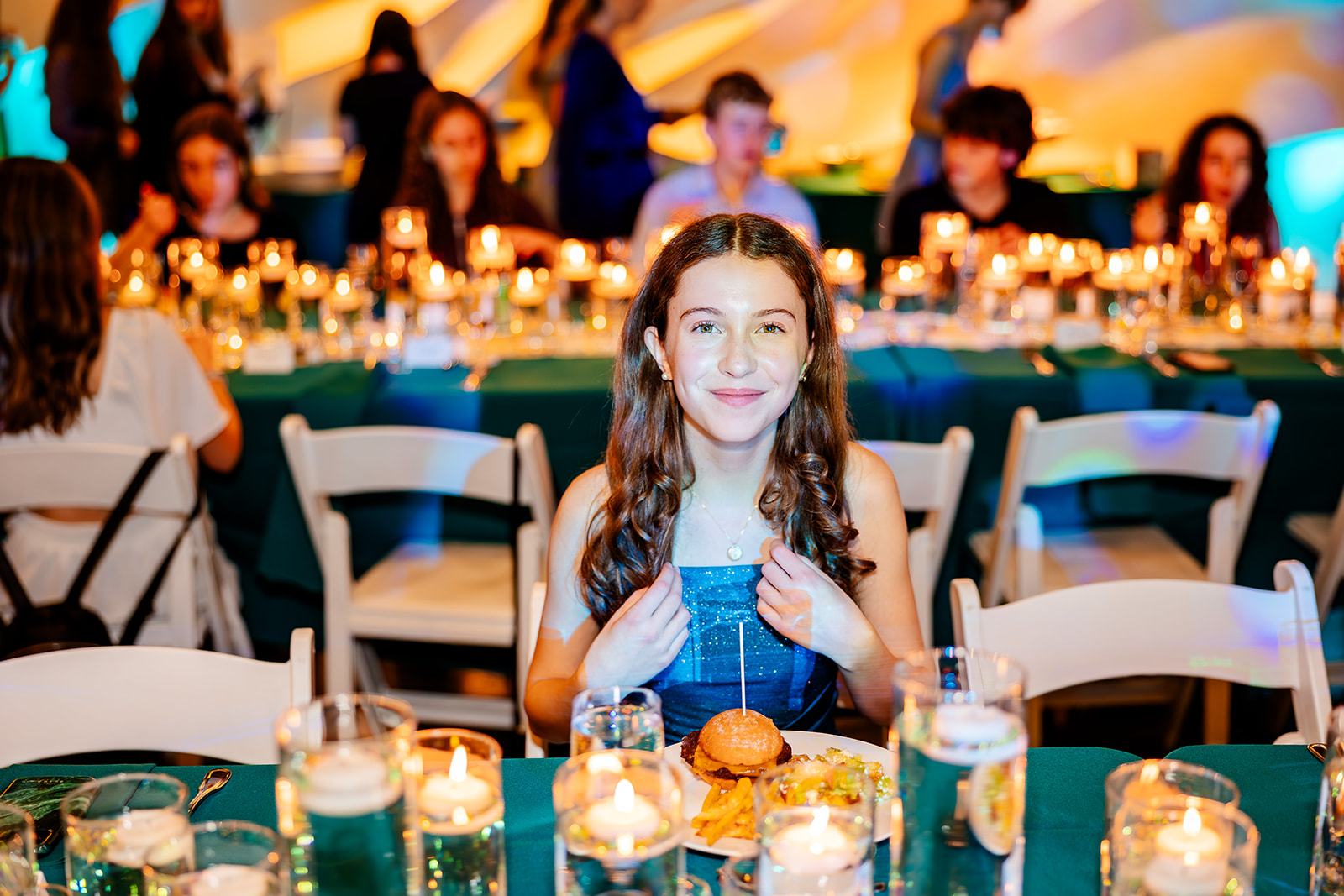 A happy teen girl sits for a meal at a Bat Mitzvah catered by a bakery in Sammamish