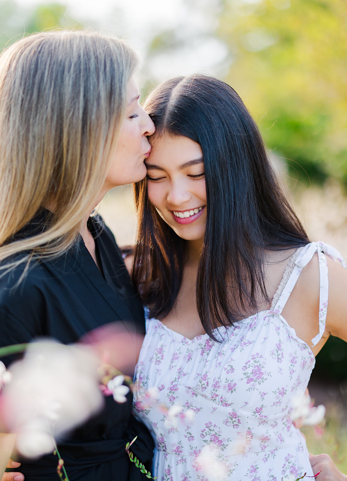 A proud mom kisses the forehead of her teen daughter in a purple dress after visiting college counselors in Seattle