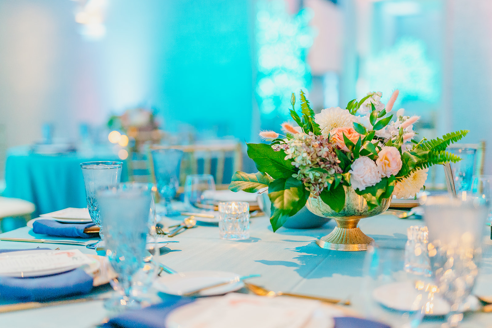 Details of a flower centerpiece on a blue reception table