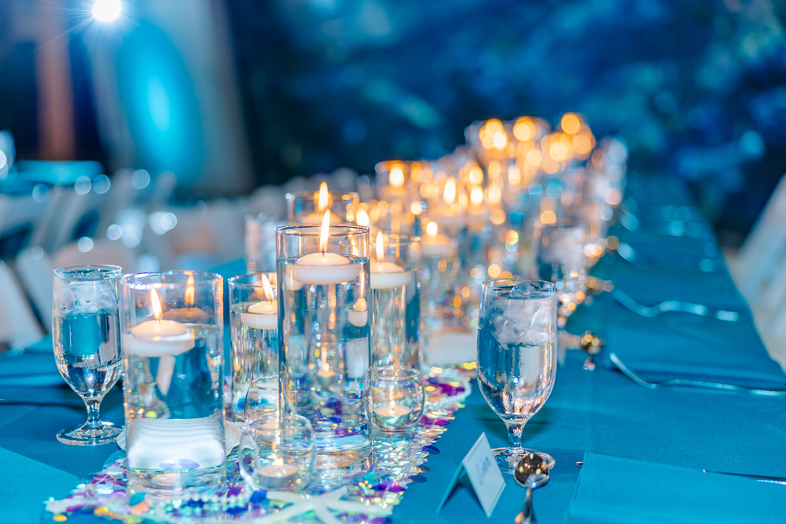Details of candles on a blue reception table