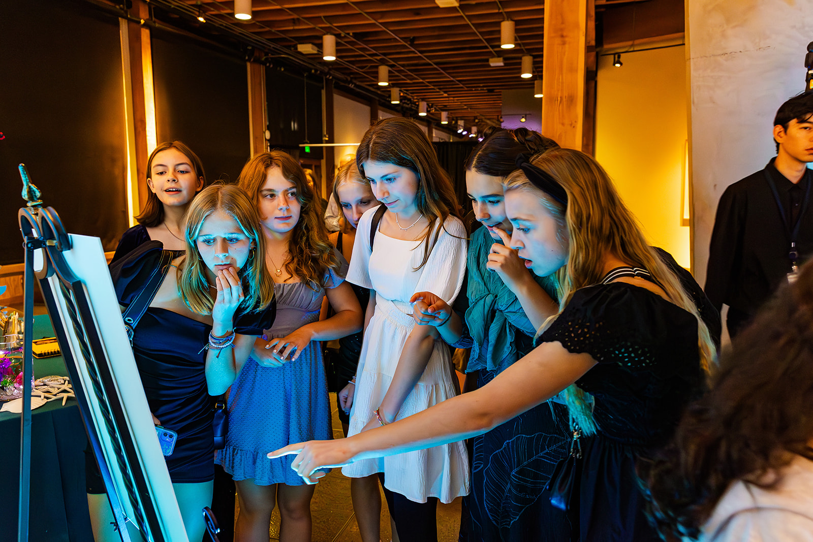 A group of girls check out their photos from a photo booth rental in Seattle